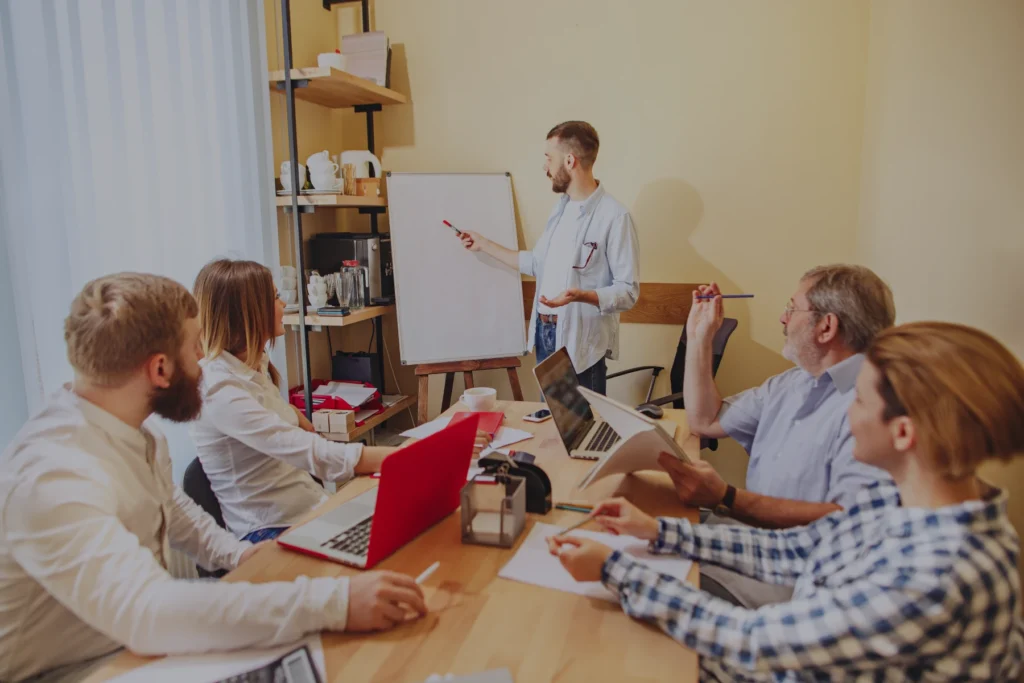 Business professionals working together on a responsive website project, highlighting the benefits of single site maintenance, cost efficiency, and future-proofing for a seamless user experience across various devices.